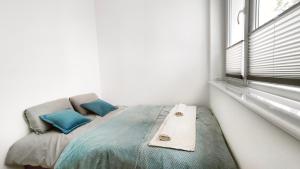 łóżko w białym pokoju z oknem w obiekcie APARTAMENTY Charzykowy w Charzykowach