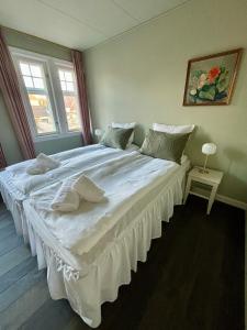 a large white bed in a room with a window at Hotel Kysten in Hasle
