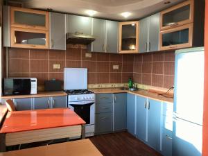 a kitchen with blue cabinets and a red counter top at City Center Apartment in Karagandy +5 photos