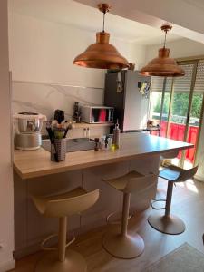 a kitchen with a counter and two bar stools at Da Laura deux pièces proche de cannes in Le Cannet