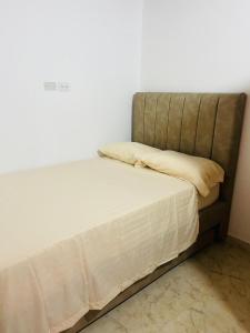 een bed met witte lakens en kussens in een kamer bij El Noral in Medellín