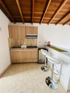 una cocina con barra y dos taburetes. en El Noral, en Medellín