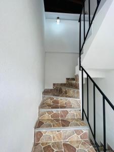 a stone staircase with a black rail and a white wall at El Noral in Medellín