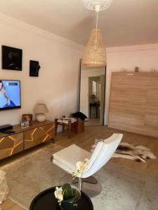 a living room with a couch and a tv at Da Laura deux pièces proche de cannes in Le Cannet