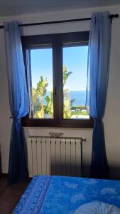 a bedroom with a window with a view of the ocean at Guest Room Perla Marina in Augusta