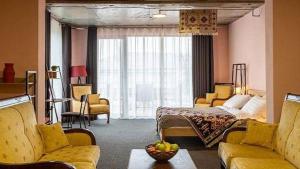 泰拉維的住宿－Paradiso Hotel，一间卧室配有床,客厅配有黄色家具