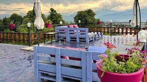 een patio met stoelen, een tafel en bloemen bij Paradiso Hotel in Telavi