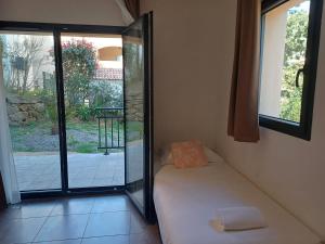 a room with a bed and a sliding glass door at Hôtel Casa Mea in Bastia