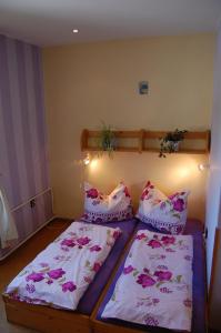 a bedroom with two beds with pink and white pillows at Penzion Eliska in Horní Planá