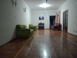 un soggiorno con 2 divani verdi e un pavimento in legno di Espaço temporada Gardenias Guaratinguetá Proximo Basilica de Aparecida a Guaratinguetá