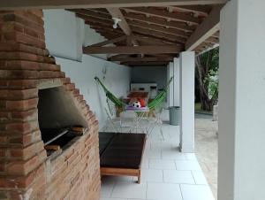 a patio with a brick fireplace and a hammock at Espaço temporada Gardenias Guaratinguetá Proximo Basilica de Aparecida in Guaratinguetá