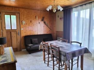 een eetkamer met een tafel en stoelen en een bank bij Maison avec jardin de 600 m2 au cœur des cévennes in Sénéchas