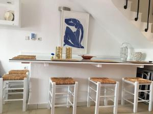 a kitchen with a counter with three stools at Hara's House 1 in Gerakini