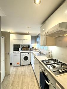 La cocina está equipada con electrodomésticos blancos y fogones. en Chester City-Walls Overlooking River (Central Location), en Chester