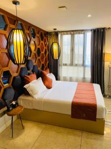 a bedroom with a large bed with two lamps at Boun's Hotel in Yaoundé