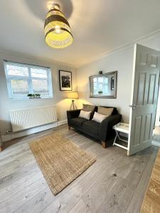 sala de estar con sofá negro y alfombra en Chester City-Walls Overlooking River (Central Location), en Chester