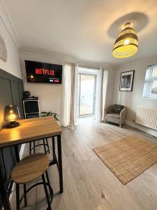 a living room with a table and a tv at Chester City-Walls Overlooking River (Central Location) in Chester