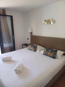 a large white bed with two pillows on it at Hôtel Casa Mea in Bastia