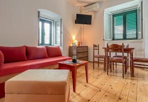 a living room with a red couch and a table at TerraMar Apartments in Baška Voda
