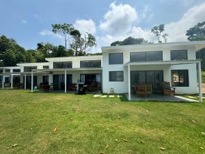 a large white house with a large yard at Canavida Villas & Resort in Uvita