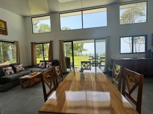 - un grand salon avec une grande table et des fenêtres dans l'établissement Canavida Villas & Resort, à Uvita