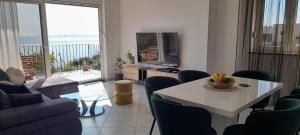 sala de estar con mesa, sillas y TV en Appartamento No. 1 en Opatija