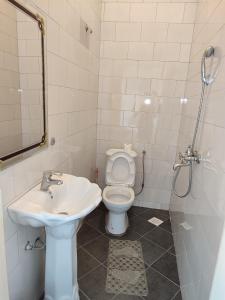 een badkamer met een wastafel, een toilet en een douche bij Garden Courts Hotel Masaka in Masaka