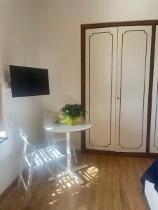 a room with a table and a chair and a tv at La Terrazza sul Tigullio in Rapallo