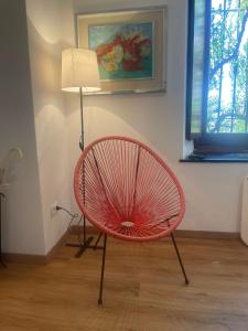 una silla roja sentada en una habitación con lámpara en La Terrazza sul Tigullio, en Rapallo