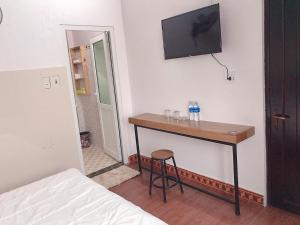 a room with a table and a television on a wall at Hoa Mai Hotel in Dong Hoi