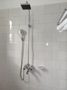 a shower with a shower head in a bathroom at Garden Courts Hotel Masaka in Masaka
