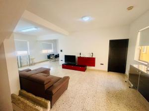 ein Wohnzimmer mit einem Sofa und einem TV in der Unterkunft 2 bedroom 2 bathroom Apartment in Sliema