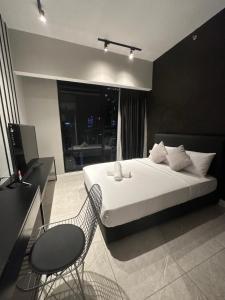 a bedroom with a bed and a table and a chair at Maxx Royal Suites at Axon Kuala Lumpur in Kuala Lumpur