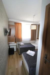 Un pat sau paturi într-o cameră la Metrohill Hotel