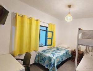 een slaapkamer met een bed en een geel gordijn bij Casa de Playa Tortugas Casma, Habitación 4 a 6 personas con 1 baño in Tortuga