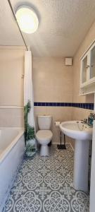 a bathroom with a toilet and a tub and a sink at Botanic Residence in Liverpool