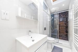 een witte badkamer met een wastafel en een toilet bij Spot Homes Guest House in Londen