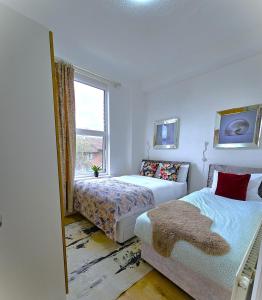 a bedroom with two beds and a window at Botanic Residence in Liverpool