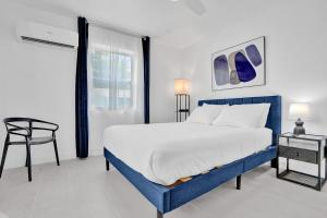 a bedroom with a blue and white bed and a chair at Hallandale Beach Family Vacation Home Backyard in Hallandale Beach +23 photos