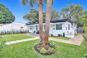a house with a palm tree in a yard at Hallandale Beach Family Vacation Home Backyard in Hallandale Beach
