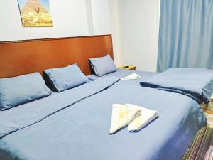 two beds in a room with blue sheets and pillows at fantastic nine pyramids in Cairo