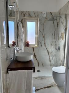 Baño blanco con lavabo y aseo en Gio Luxury Home Mare, en Leporano Marina
