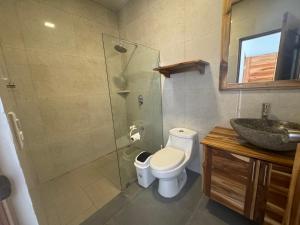 a bathroom with a shower and a toilet and a sink at Canavida Villas & Resort in Uvita