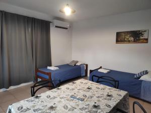 a room with two beds and a table and chairs at Ezeiza Home in Ezeiza