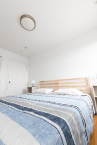 a bedroom with a bed with a blue and white blanket at Pristine 2-Bed Apt with Skyline Views - mins to NYC in Union City