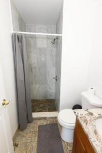 a bathroom with a shower and a toilet at Pristine 2-Bed Apt with Skyline Views - mins to NYC in Union City