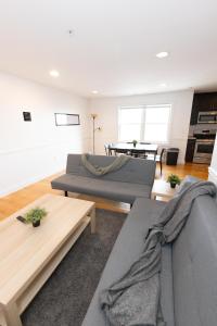 a living room with two couches and a table at Pristine 2-Bed Apt with Skyline Views - mins to NYC in Union City