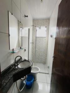 uma casa de banho com um WC, um lavatório e um chuveiro em Hotel Mãe Rainha em Aparecida