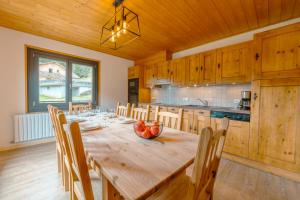 een grote keuken met een houten tafel en stoelen bij Etoile des Vents in Morzine