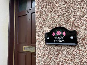 una señal en el lateral de un edificio al lado de una puerta en TAIGH CATHIE, 67 Alma Road, en Fort William 2 fotos más